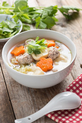 Clear Soup with Vegetables and Meatballs in white bowl.