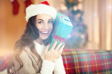 Festive brunette holding gift at christmas