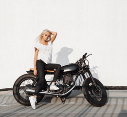 Naklejka na ściany i meble Biker girl sitting on vintage custom motorcycle