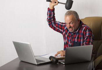 Angry man crashing laptop
