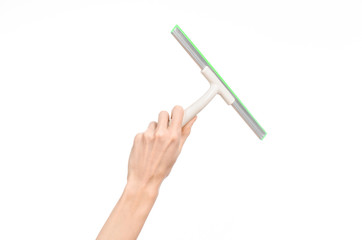 Household cleaning and washing windows theme: man's hand holding a green scraper windows isolated on a white background in the studio.