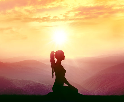 Woman meditating in the mountains. 
