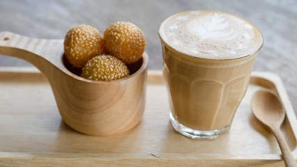 A glass of hot latte art coffee and candy eggs swan