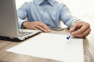 uomo in ufficio con notebook che firma il contratto per assunzione di lavoro