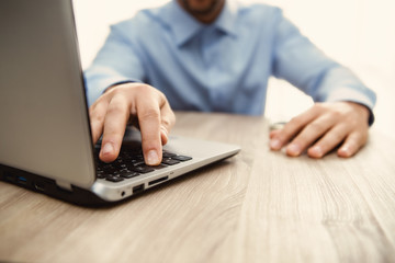 mano di uomo che schiaccia il bottone della tastiera di un notebook