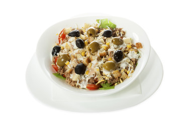 Delicious tuna salad with lettuce, tomato, egg, cucumber, olives, served in a white bowl. Isolated on white.