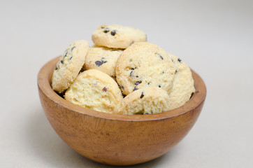 cookies in wooden bowl on brown background