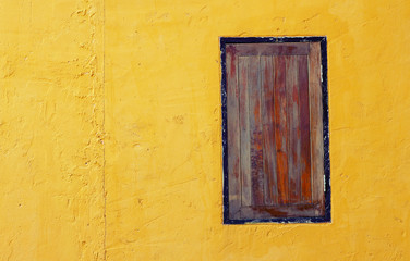 old dirty window on yellow wall