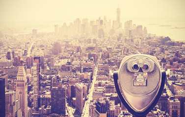 Retro vintage toned tourist binoculars over Manhattan, NYC, USA.