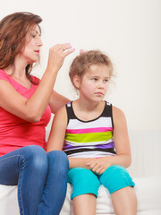 Mother combing hair for daughter