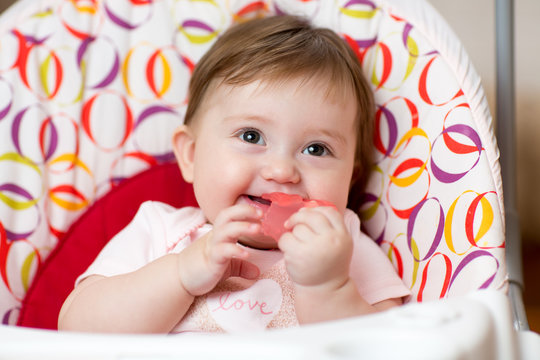 Baby With Teething Ring Sitting In Craddle