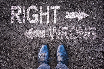 Feet and words right and wrong painted on an asphalt road, life choice concept