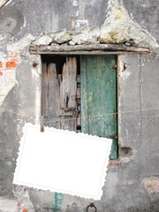 One hanged postcard with clothes pin on old damaged wooden window background