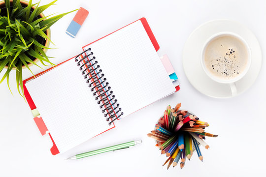 Office desk table with supplies, flower and coffee cup