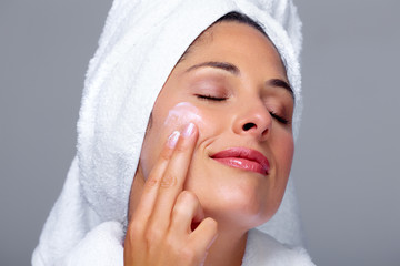 Beautiful woman face with moisturising  cream.
