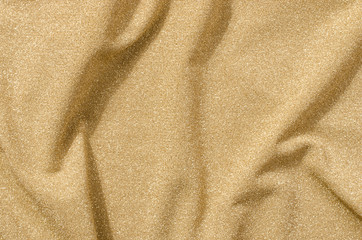 Yellow gold textile pattern as a background. Close up on crumpled sparkly gold material texture fabric.