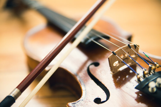 Vintage violin on hardwood floor background. Music, violin lessons, and music instrument concept