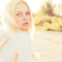 Naklejka premium Blonde girl close-up portrait in sun-rays