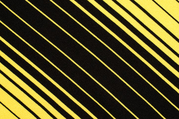 Striped black and yellow textile pattern as a background. Close up on diagonal stripes material...