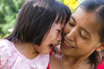 Little asian girl crying with her mom