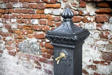 Detail of a fountain against a brick wall