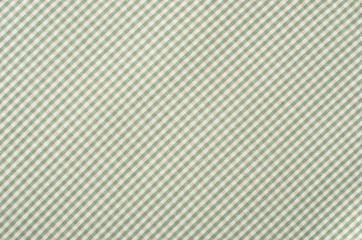 Fototapeta premium Close up on checkered tablecloth fabric. Green with white tartan square pattern as background.