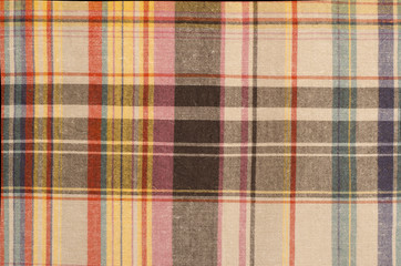 Scottish tartan pattern. Orange and green with yellow plaid print as background. Colored lines and square pattern. Scottish checked fabric.
