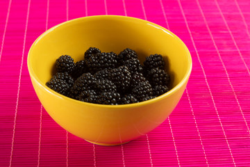 Fresh blackberries in a yellow bowl