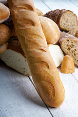 Baguette and fresh bread on a white table