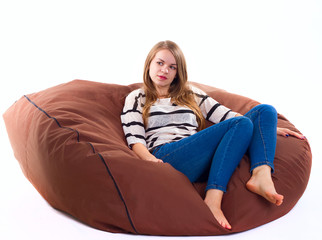 girl sitting on a braun beanbag chair.