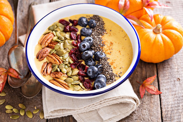 Pumpkin smoothie bowl with chia seeds, pecans, cranberries