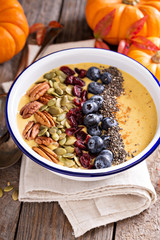 Pumpkin smoothie bowl with chia seeds, pecans, cranberries
