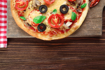 Tasty pizza with vegetables and basil on table close up