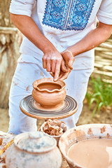 Hands of potter do clay pot, ceramic, people, outdoors. Ethnic