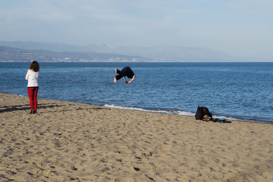 Acr&oacute;bata dando una voltereta en la playa