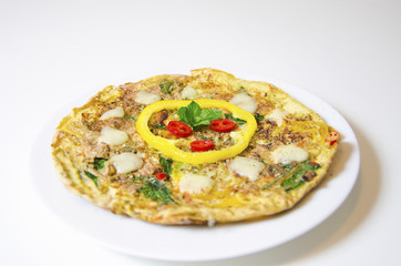 Spinach chili and pepper omelette.A spinach, chili, mint and pepper omelette in a dish in white background. A healthy diet meal omelet.