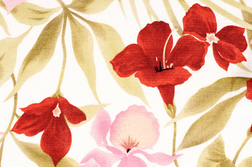Colorful tropical floral pattern on fabric. Pink and red flowers with green leaves print as background.
