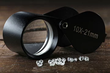 Fototapeten echte Rohdiamanten mit Einschlaglupe auf rustikalem Holzhintergrund © Björn Wylezich