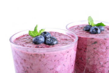 Glass of blueberry smoothie isolated on white