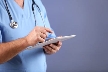 Doctor with digital tablet on colorful background