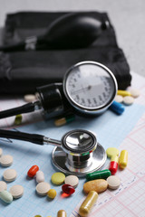 Blood pressure meter, pills and stethoscope, on grey background