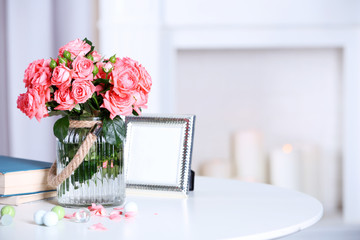 Beautiful rose in vase on table in room