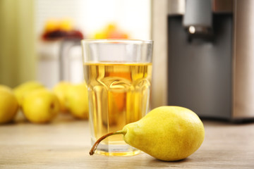 Juicer and pear juice on kitchen table
