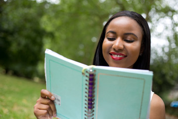 Fototapeta premium girl in the park reading a notebook