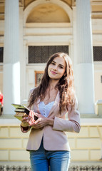 young caucasian female student with books and tablet on campus, student study in campus area