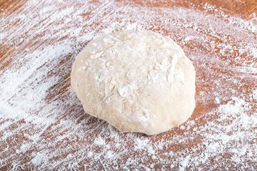 Fototapeta na wymiar Laghman dough on an old wooden worn board with flour. Toned