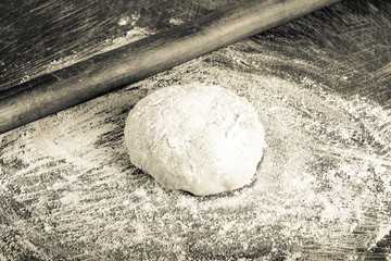 Laghman dough on an old wooden worn board with flour. Toned