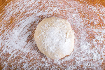 Laghman dough on an old wooden worn board with flour
