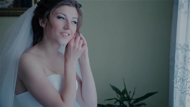 Bride wears earrings