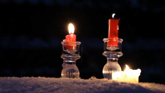 Red candles in crystal candlesticks stand on snow and off. It's cold and dark. Snow idet.Oschuschenie winter, holiday, Christmas and New Year. Fairy tale, solemnity and romanticism. Magic night.